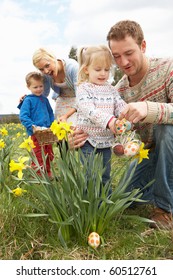 Family On Easter Egg Hunt In Daffodil Field