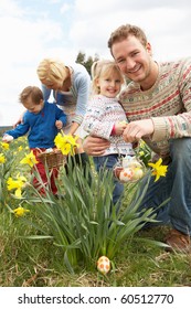 Family On Easter Egg Hunt In Daffodil Field