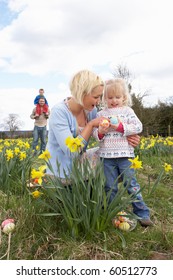 Family On Easter Egg Hunt In Daffodil Field