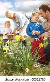 Family On Easter Egg Hunt In Daffodil Field