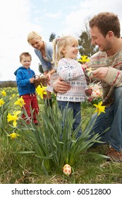 Family On Easter Egg Hunt In Daffodil Field