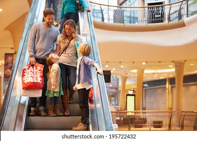 Family On Escalator In Shopping Mall Together