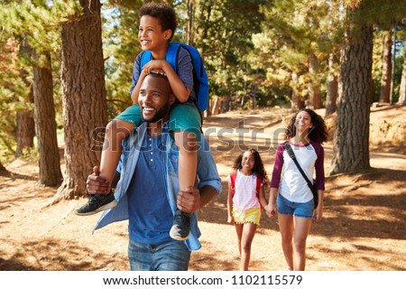 Family On Hiking Adventure Through Forest