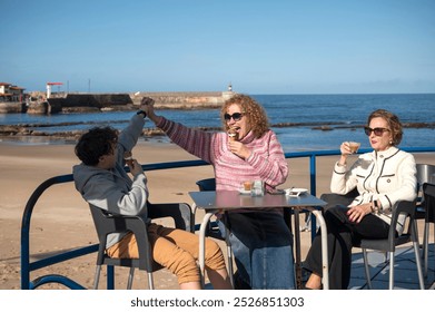 family on holiday having a coffee and an ice-cream on a beautiful terrace by the sea - Powered by Shutterstock