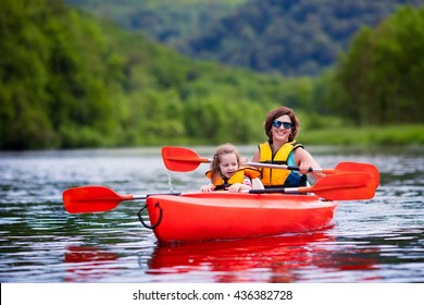 Family On Kayaks And Canoe Tour. Mother And Child Paddling In Kayak In A River On A Sunny Day. Children In Summer Sport Camp. Active Preschooler Kayaking In A Lake. Water Fun During School Vacation.