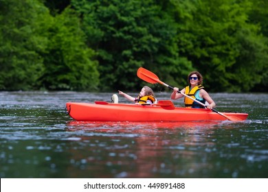 Family On Kayaks And Canoe Tour. Mother And Child Paddling In Kayak In A River On A Sunny Day. Children In Summer Sport Camp. Active Preschooler Kayaking In A Lake. Water Fun During School Vacation.