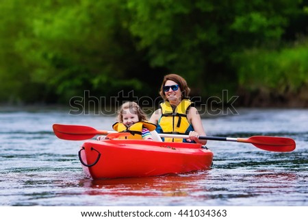 Family on kayaks and canoe tour. Mother and child paddling in kayak in a river on a sunny day. Children in summer sport camp. Active preschooler kayaking in a lake. Water fun during school vacation.