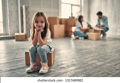 Family On Moving Day. Attractive Young Woman And Handsome Bearded Man With Their Cute Little Daughter Are Happy To Move Into New Home.