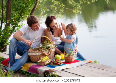 Family On Picnic Near The Lake