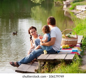 Family On Picnic Near The Lake