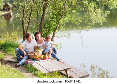 Family On Picnic Near The Lake