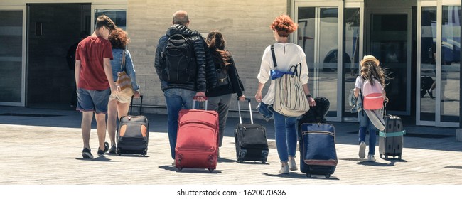 Family On A Plane. Friends Returning From Vacation Walk Sad At Airport Departures. Adults And Children Leaves Happy For Carefree Days Of Break. Group Of People Traveling With Luggages After Holidays