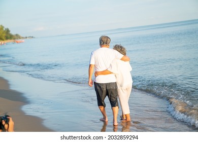 Family On Summer Beach Vacation, Healthy Older Couple Running On Sea Beach, Concept For 
Caring For The Elderly, Caregiving To Older Persons And Relations Of The Family To Support Elderly State