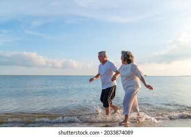 Family On Summer Beach Vacation, Healthy Older Couple Running On Sea Beach, Concept For 
Caring For The Elderly, Caregiving To Older Persons And Relations Of The Family To Support Elderly State