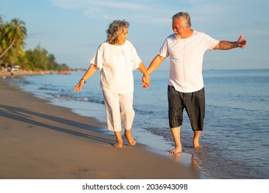 Family On Summer Beach Vacation, Healthy Older Couple Running On Sea Beach, Concept For Caring For The Elderly, Caregiving To Older Persons And Relations Of The Family To Support Elderly State