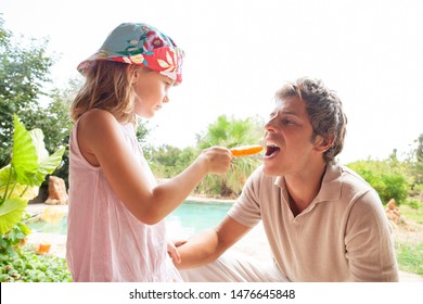 Family On Summer Tropical Holiday Villa Swimming Pool Garden Together Enjoying Vacation Abroad, Sunny Outdoors. Child Offering Father Refreshing Lolly Ice Cream, Fun Leisure Travel Lifestyle.