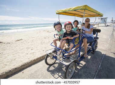 Family On A Surrey Bike Ride Along The Coast Of California