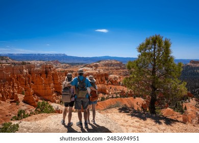 Family on top of the mountain enjoying beautiful view on hiking trip in Utah. Family with arms around each other looking at mountain scenery. Rim Trail. Bryce Canyon National Park, Utah, USA - Powered by Shutterstock