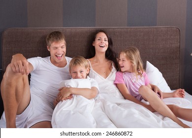 Family On Vacation In A Hotel Room Bed 