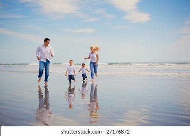 Family on vacation running on the beach