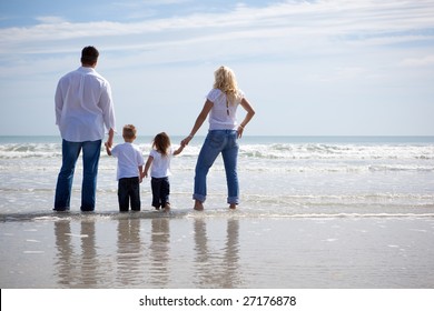 Family On Vacation Standing At The Ocean, Looking Ahead