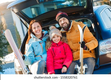 Family On A Winter Vacation Spending Time Together Outdoors Sitting In The Car Trunk Looking Camera Smiling Cheerful Close-up