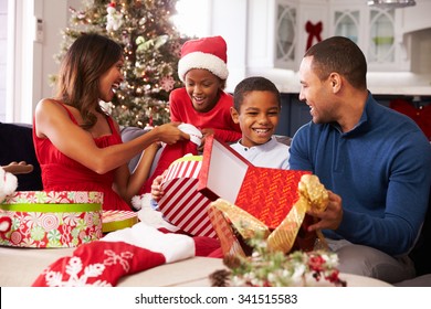 Family Opening Christmas Presents At Home Together