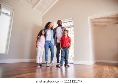 Family Opening Door And Walking In Empty Lounge Of New Home