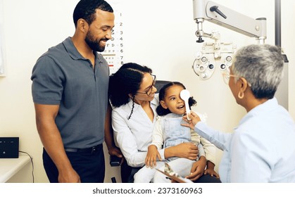 Family, optometry and eye exam with a woman doctor in a clinic to see a patient for vision assessment. Mother, father and daughter at the optometrist for an appointment to test eyesight for children - Powered by Shutterstock