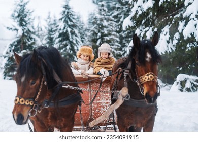 Family outings on horseback and sleigh rides. Two happy children are riding on a horse-drawn carriage. Merry Christmas and Happy New Year greeting card. - Powered by Shutterstock