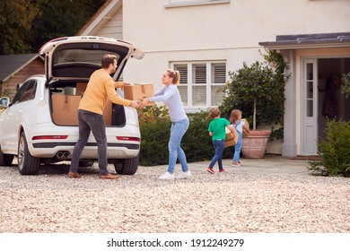 Family Outside New Home On Moving Day Loading Or Unloading Boxes From Car - Powered by Shutterstock