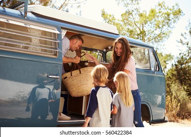 Family Packing Up Their Camper Van For A Road Trip Vacation