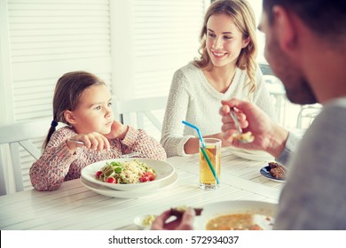 Family, Parenthood, Food And People Concept - Happy Mother, Father And Little Girl Eating Pasta And Soup For Dinner At Restaurant Or Cafe