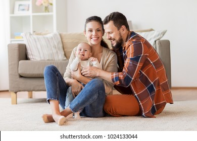 family, parenthood and people concept - happy mother, father and baby at home