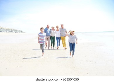 Family, Parents, Grandparents And Grandkids Walking On The Beach