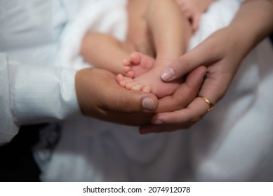 Family parents hold a foot of a newborn child baby - Shutterstock ID 2074912078