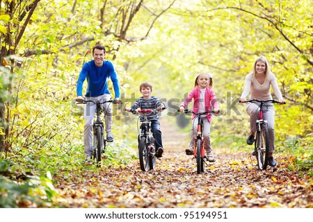The family in the park on bicycles