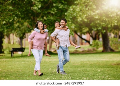 Family, park and walking with piggy back for wellness or happiness, together in nature for bonding. Mixed race people, children and parents on grass for vacation in Europe, smile for travel with kids - Powered by Shutterstock