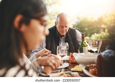 Family party, celebration and praying before a lunch, Christmas and gathering with food in a backyard. Holding hands, gratitude and friends with a prayer for Thanksgiving dinner on a patio garden - Powered by Shutterstock