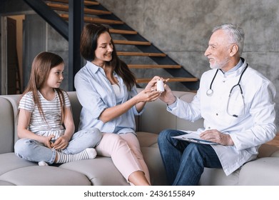 Family pediatrician visit mother and her child at home. Smiling man doctor prescribing medicine, giving vitamins bottle to patient. Concept of pharmacy, medication and treatment plan - Powered by Shutterstock