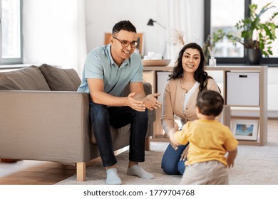 family and people concept - happy mother, father and baby son at home