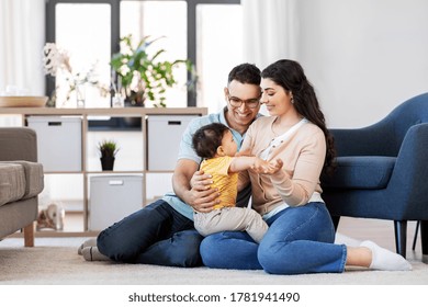 Family And People Concept - Happy Mother, Father And Baby Son Sitting On Floor At Home