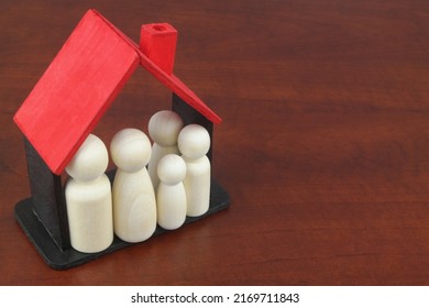 Family people figures in wooden house model with copy space for text. Safety, protection and insurance concept. - Shutterstock ID 2169711843