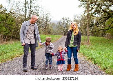 Family Photo Of A Mother, Father, And Their Two Kids A Boy And Girl Outdoors In The Fall.