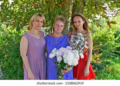 Family Photo Session Of An Elderly Mother And Her Adult Daughters.