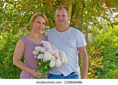 Family Photo Session Husband And Wife With A Bouquet Of Flowers.