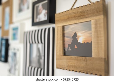 Family Photos In Different Frames On A Wall