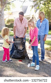 Family Picking Up Litter In Suburban Street