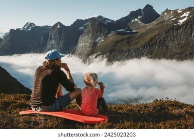 Family picnic father and daughter eating snacks in mountains travel vacations camping outdoor dad with child hiking together active lifestyle adventure trip parent and kid enjoying views in Norway  - Powered by Shutterstock