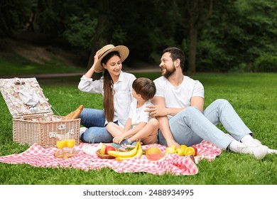 Family picnic. Happy parents and their son spending time together in park - Powered by Shutterstock